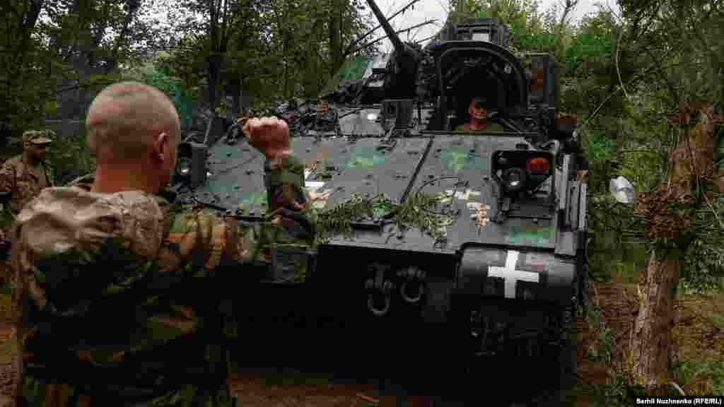 Un soldat ucrainean coordonează M2 Bradley pe poziție. &nbsp;