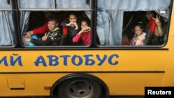 Copii luându-și rămas-bun în timpul evacuării din orașul Kupiansk, ocupat de Rusia, în apropierea orașului Harkov, 30 mai 2022.