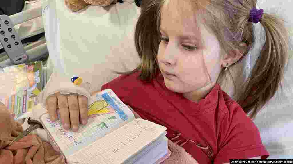 Milana je imala šest godina kada je projektil pogodio kuću njene porodice u blizini Hostomela, u blizini Kijeva, ubivši joj majku pred djetetovim očima, 28. februara 2022. godine. Šrapneli od udara teško su ranili Milanina stopala i noge. U bolničkom krevetu između operacija crtala je slike i pisala poruke "mojoj mami na nebu", kao što je ova prikazana na fotografiji.