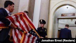 Членови на персоналот носат американски знамиња во канцеларијата на претседателот на Претставничкиот Дом, додека негов претседател беше Кевин Мекарти.