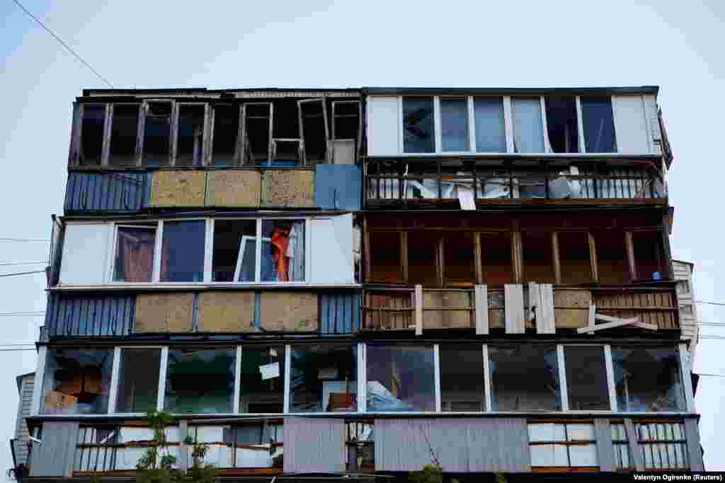 O vedere a clădirii de apartamente arată ferestrele sparte și fațada deteriorată.
