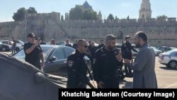 Policë izraelitë duke biseduar me një prift armen në Kopshtin e Lopës, në Jerusalem. Foto: Khatchig Bekarian
