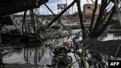 Детски колички, изоставени сред останки от разрушен мост в Киев, 7 март 2022 г.