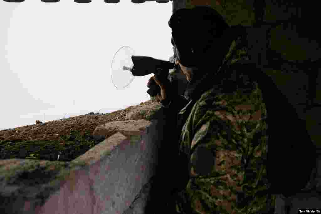 An Armenian soldier uses a listening device at a position near the Lachin blockade during a foggy day on December 21. At some points near the southeastern border, military outposts of Azerbaijan and Armenia are just meters apart. 