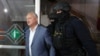 Fostul președinte Igor Dodon escortat de polițiști la audierile de la tribunal, Chișinău, 26 mai 2022.