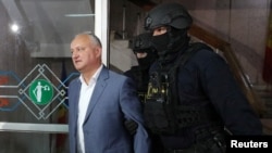 Fostul președinte Igor Dodon escortat de polițiști la audierile de la tribunal, Chișinău, 26 mai 2022.