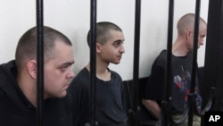 Британиялык Эйден Аслин, Шон Пиннер жана марокколук Саадун Брагим сот залында. Донецк шаары.