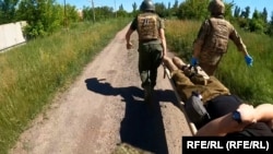 Украинските воени медицинари носат ранет војник