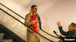 Liderul alianței radicale AUR, George Simion, coborând cu un escalator, la București, pe 1 decembrie 2024, mimând intrarea pe scena politică lui Donald Trump, înainte să candideze pentru primul mandat de președinte în SUA, în 2016.