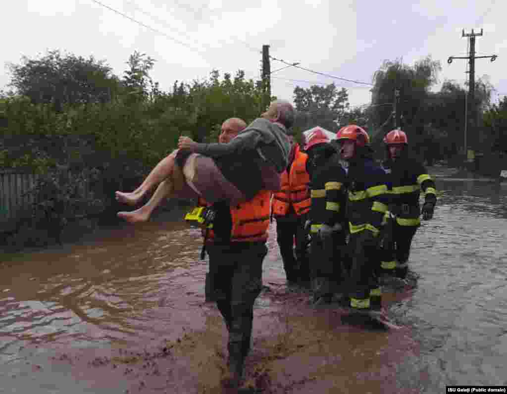 Un bărbat este salvat de pompieri din locuința sa după inundațiile care au afectat județele Galați și Vaslui. 