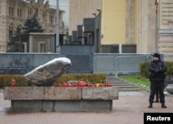 Un polițist la memorialul Piatra Solovețki unde au fost depuse flori în ajunul zilei comemorării victimelor represiunii politice, Moscova, Rusia, 29 octombrie 2023.