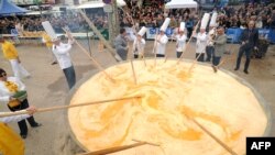 Membrii Frăției Omletei Uriașe din Bessières gătesc o omletă uriașă în cadrul sărbătorilor pascale, pe 28 martie 2016