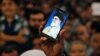 Një Iranian mban në duar një telefon, ku shfaqet fotografia e liderit suprem të Iranit, Ayatollah Ali Khamenei 