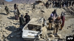 Personalul de securitate taliban inspectează o mașină avariată la două zile după loviturile aeriene ale Pakistanului în districtul Barmal din estul provinciei Paktika, în decembrie. 