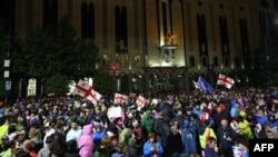Protestatari flutură steagurile Georgiei și UE în timpul protestului împotriva proiectului de lege privind „influența străină”. Tbilisi, 12 mai 2024.