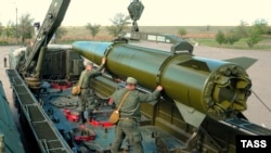 Военнослужащие заряжают ракету на установке "Искандер-М" во время учений в Астраханской области, май 2015 года