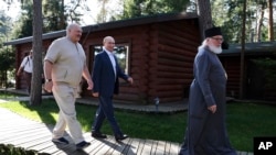 Una din cele mai recente fotografii ale liderului de la Minsk (în stânga) îl arată în compania lui Putin și a unui monah la o mănăstire din Karelia, pe 26 iulie 2024.