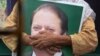 FILE: A supporter of former Pakistani Prime Minister Nawaz Sharif holds his picture at Lahore airport ahead of his arrival in July 2018.