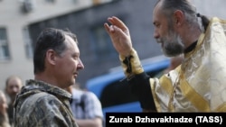 Священик благословляє у Донецьку російського полковника Ігоря Гіркіна (Стрєлкова), який на той час був одним із ватажків угруповання «ДНР», що визнане в Україні терористичним. Липень 2014 року
