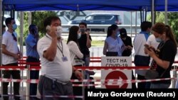 Люди в защитных масках у центра тестирования на коронавирус. Алматы, 8 июля 2020 года.