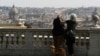 Un cuplu cu un cățel privind panorama Romei, cu bazilica San Pietro în fundal