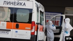 Амбулантно возило и здравствени работници пред болница во Бугарија.