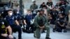 Minneapolis: ofițeri îngenunchează în semn de solidaritate cu cei care protestează împotriva uciderii unui afroamerican, în timp ce era reținut de polițiști albi, 1 iunie 2020.