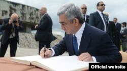 Լեհաստան - Հայաստանի նախագահ Սերժ Սարգսյանը գրառում է կատարում Մայդանեկ թանգարանային համալիրի պատվավոր հյուրերի գրքում, 26-ը հունիսի, 2013թ.