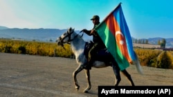 Soldat azer, purtând steagul țării sale, călare, la Gandja, al doilea oraș ca mărime din Azerbaidjan, nu departe de frontiera cu Armenia, 10 noiembrie 2020