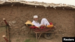 تصویر له ارشیفه، پاکستان کې یو افغان کډوال د خپل کور مخې ته