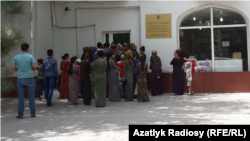 Aşgabatda bir döwlet dükanynyň öňünde iýmit önümlerini satyn almak üçin nobata garaşýan adamlar. Illýustrasiýa suraty. 