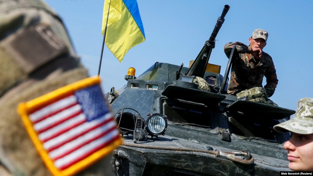 Воен инструктор на Армијата на САД покрај украински војници за време на мултинационалните вежби "Rapid Trident 2019" во Меѓународниот центар за одржување на мирот и безбедност во близина на Лавов, 24 септември 2019 година.