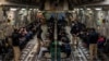 Migranții reținuți așteaptă decolarea într-un zbor C-17 Globemaster III al Forțelor Aeriene ale SUA pe Aeroportul Internațional Tucson din Tucson, Arizona, 23 ianuarie 2025.