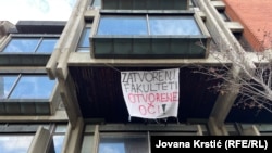 Натпис „Затворени факултети, отворени очи“ на Филозофскиот факултет во Нови Сад, 8 декември 2024 година.