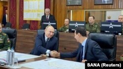 Russian President Vladimir Putin (left) shakes hands with his Syrian counterpart Bashar al-Assad in Damascus on January 7. 